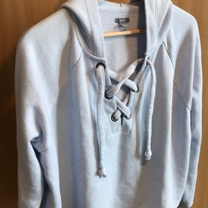 Cropped, light blue hoodie/sweater with cross-ties
